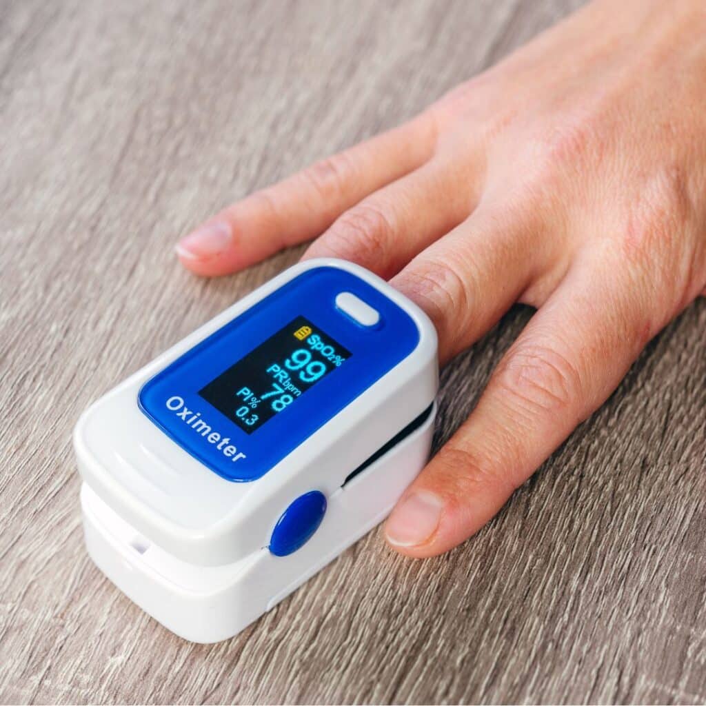 Une main avec un appareil qui permet de prendre le taux d'oxygene dans le sang